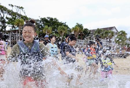 <p>　水しぶきを上げて海に入る子どもたち＝４月、鹿児島県・奄美大島</p>