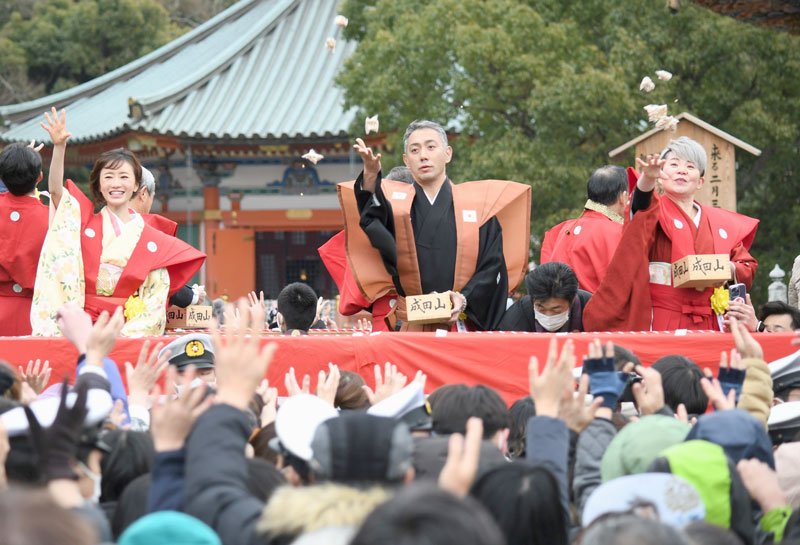 新勝寺の特設舞台で威勢良く豆をまく（左から）松本さん、市川團十郎さん、島津さん＝３日、成田市