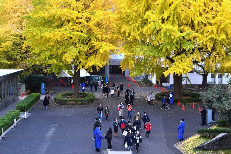 試験会場へ向かうマスク姿の受験生と保護者たち＝１日、習志野市の東邦中学校