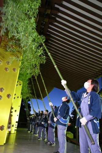 成田山新勝寺の大本堂の軒下をササ竹ではく職員たち＝１３日午前６時ごろ、成田市
