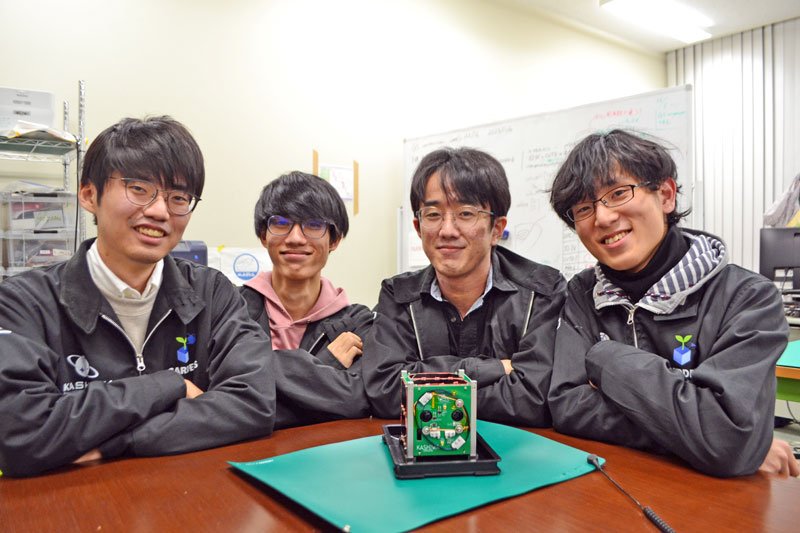 製作した千葉工大の学生たち。手前は打ち上げる機体と同じ機能を持つ試験機＝６日、習志野市の同大
