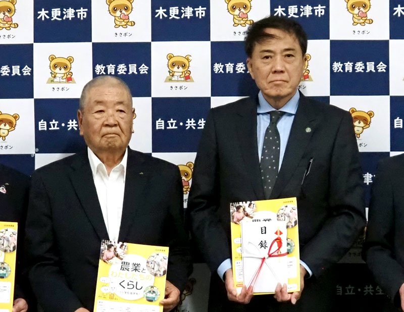 石渡組合長（左）からＪＡバンク補助教材本を寄贈される広部教育長＝木更津市
