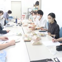 企業側と弁当のメニューを打ち合わせる鶴岡ゼミの学生ら（神田外語大提供）
