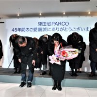 閉店を迎え、地元商店会からの花束を手に感謝のあいさつをする津田沼パルコのスタッフ＝２８日午後８時２０分ごろ
